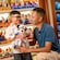 A father and his young son who is holding a Mickey Mouse plush toy, in a toy shop
